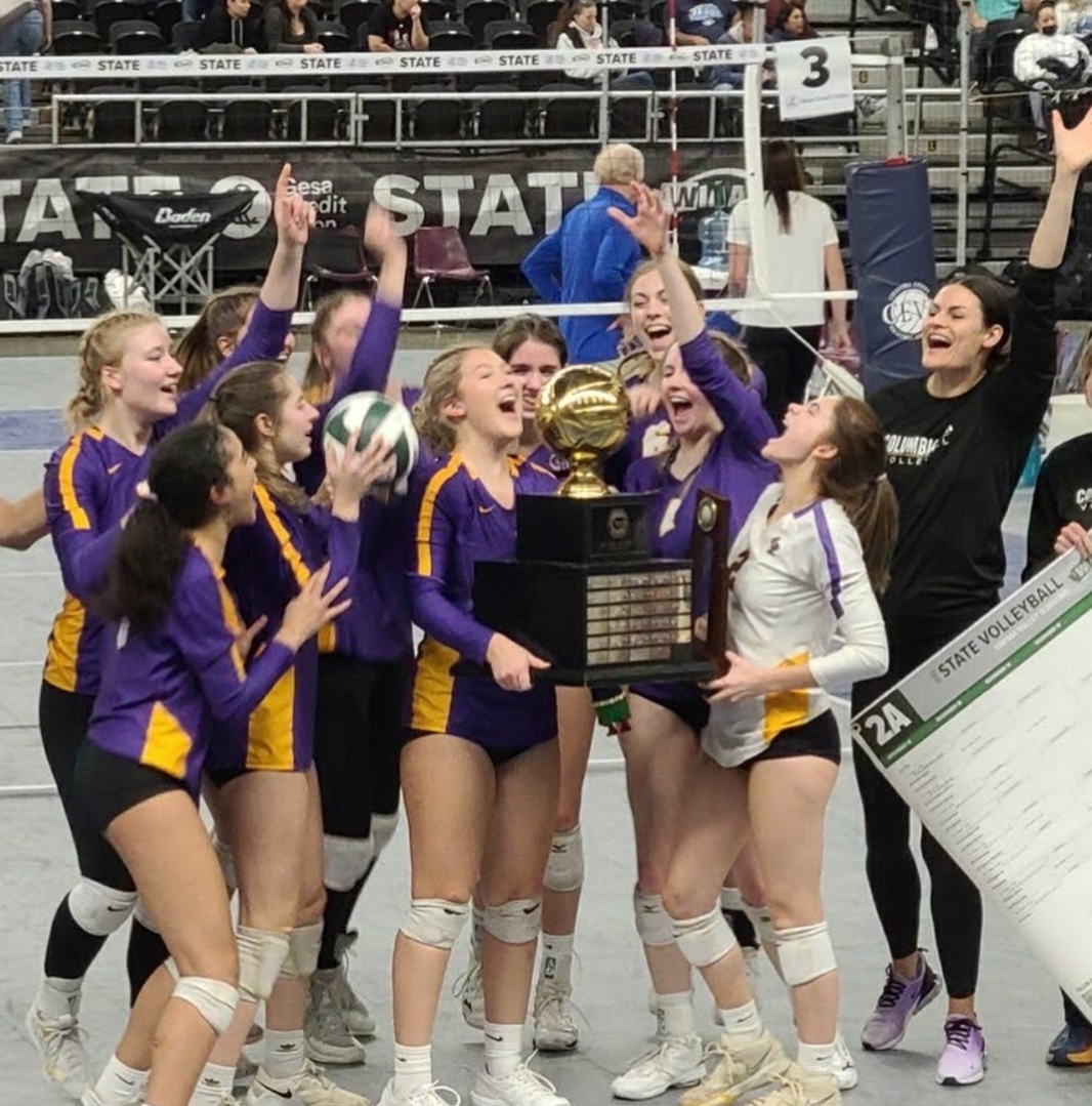 Volleyball team celebrating a championship trophy